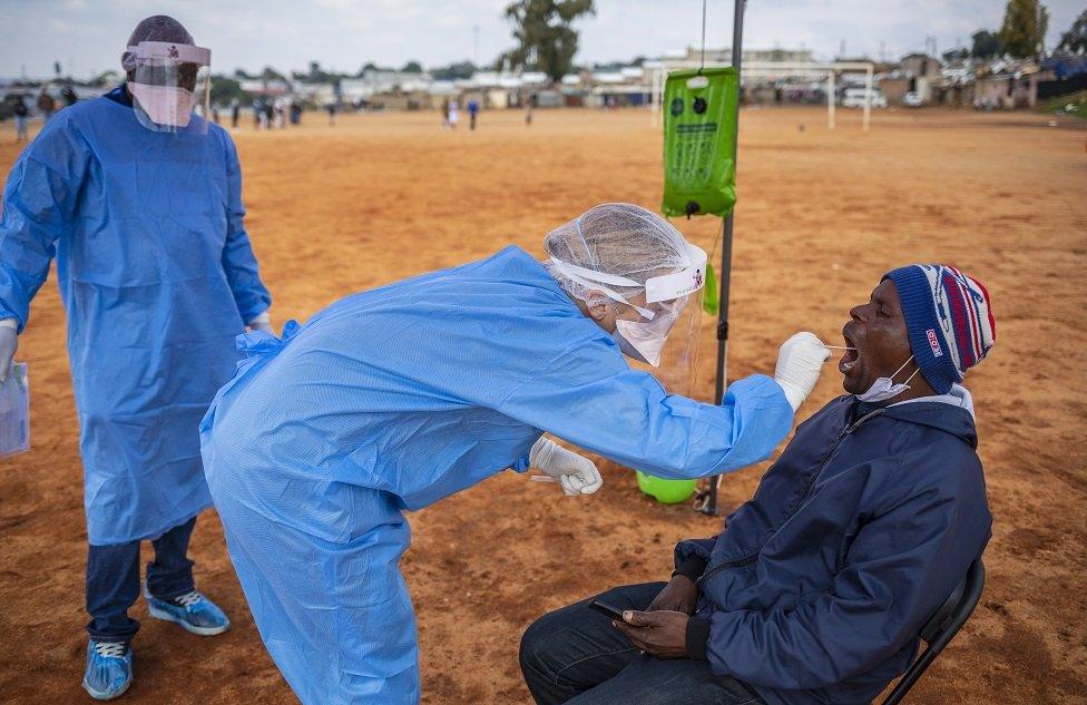 Person being tested by someone in PPE