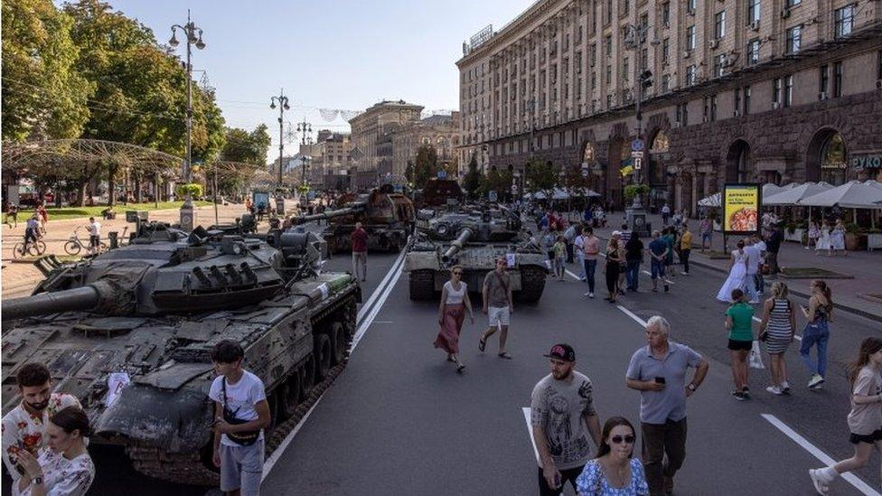 People walk past Russian armoured military vehicles that were captured in fights by the Ukrainian army, displayed in Khreshchatyk street on Independence Day, in Kyiv, Ukraine, 24 August 2022.