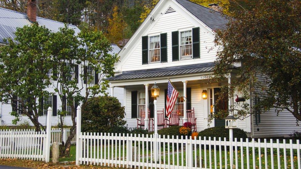 House with white picket fence and American flag