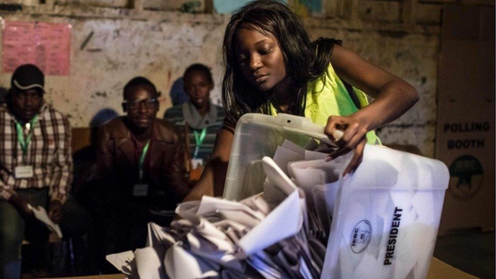 An Independent Electoral and Boundaries Commission (IEBC) official opens a ballot box at a polling station in Kiboro Primary School, in the Mathare slums of Nairobi on August 8, 2017,