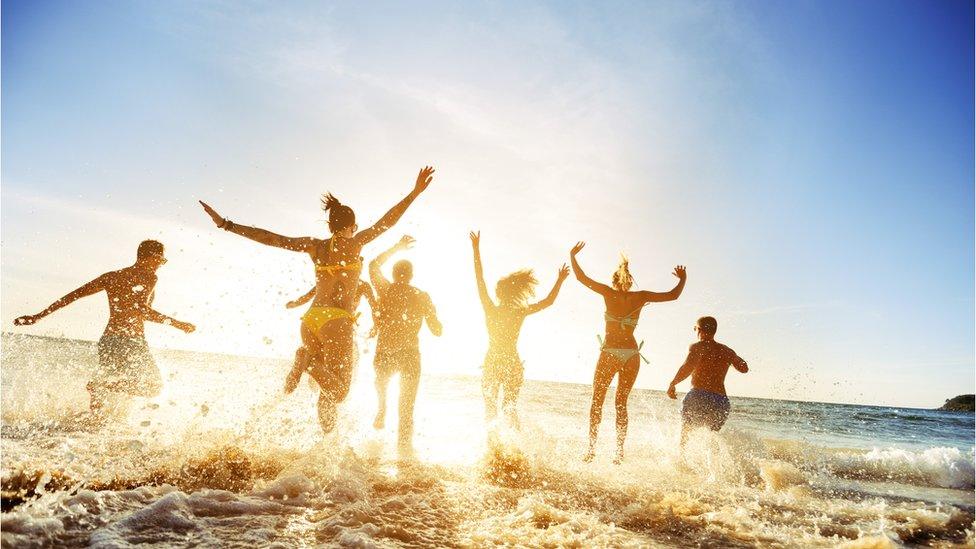 People jumping in the air on a beach