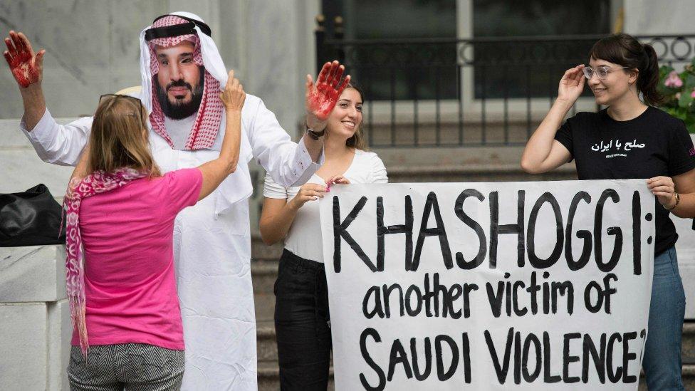 A demonstrator dressed as Saudi Arabian Crown Prince Mohamed bin Salman with blood on his hands protests with others outside the Saudi Embassy in Washington DC, on October 8, 2018