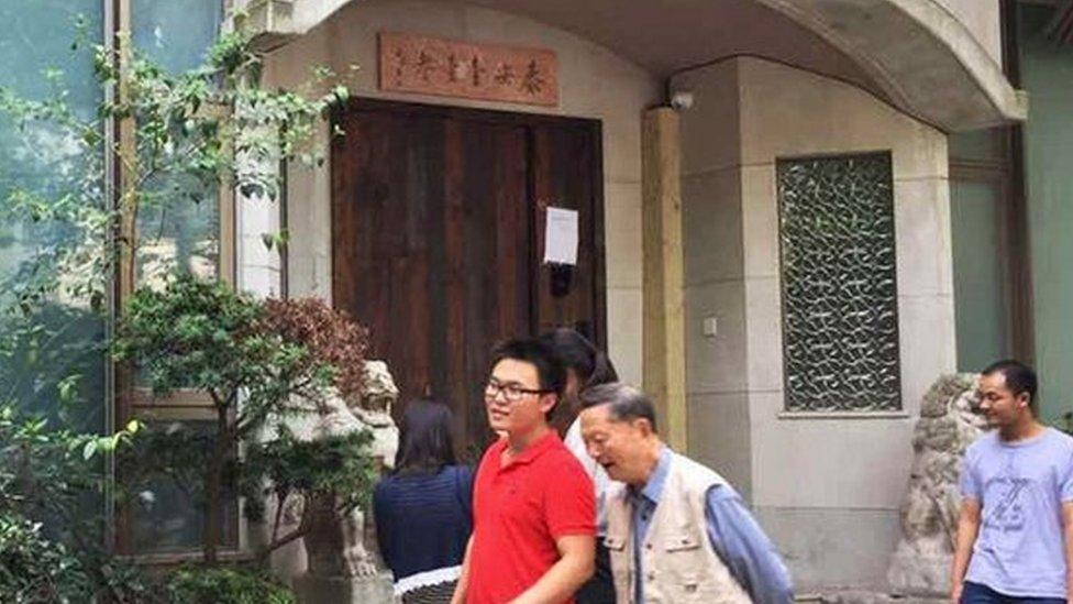 People walk past the closed Taian Table restaurant in Shanghai