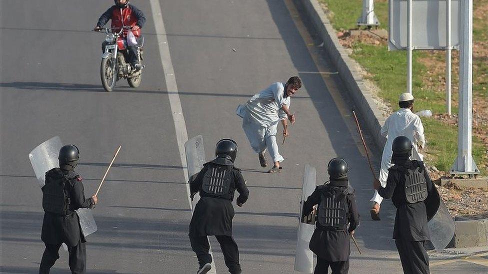 Protester throws stones towards riot police in Islamabad (27 March 2016)