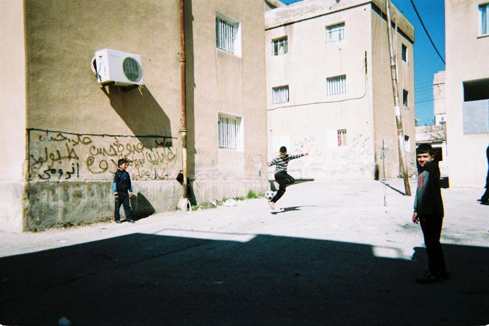 Children play football outdoors