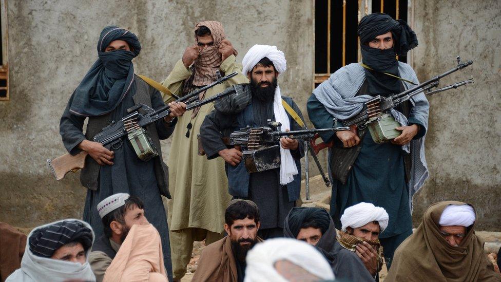 Afghan Taliban fighters listen to Mullah Mohammed Rasool, unseen, the newly-elected leader of a breakaway faction of the Taliban