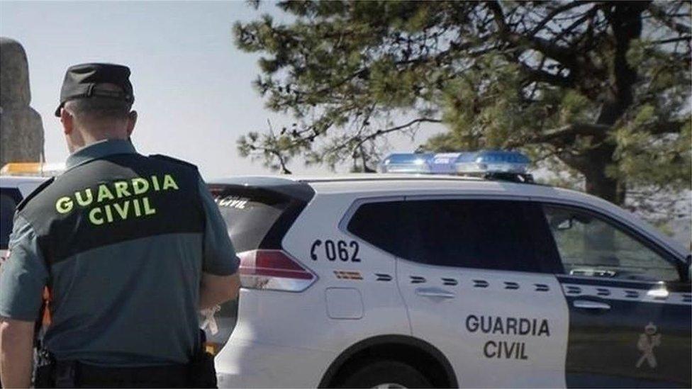 A car of the Guardia Civil is seen leaving the crime scene of a triple murder in the area of Valga