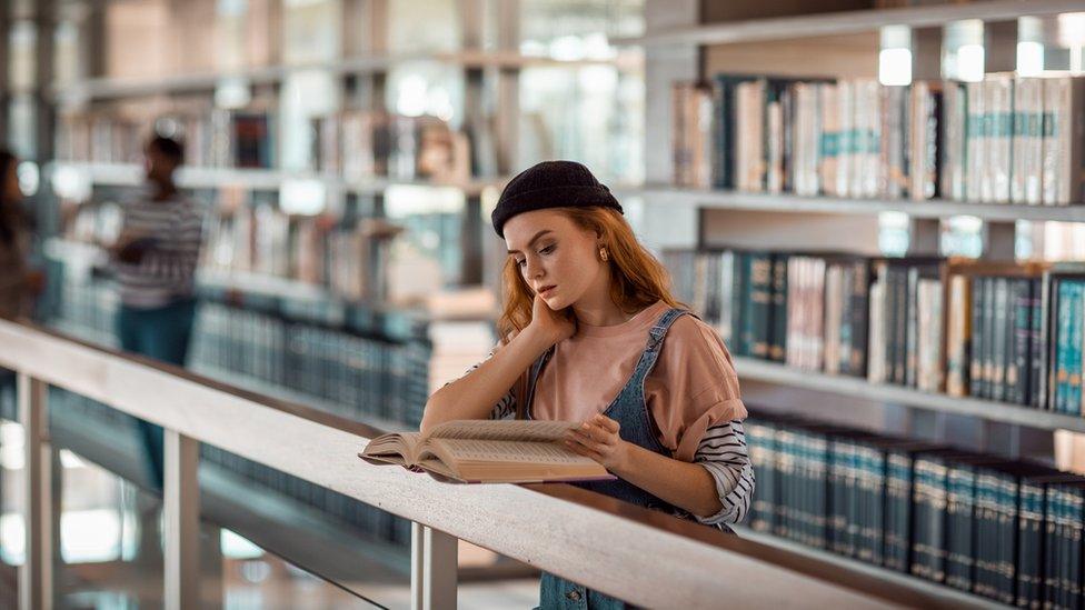 Woman reading in a library or university