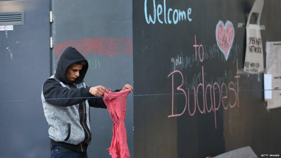 A migrant sorts through donated clothes at Keleti train station in Budapest in Budapest, Hungary, on 8 September 2015