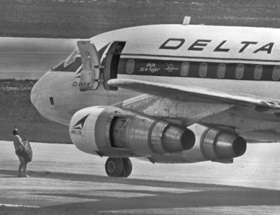 FBI agent carrying suitcase next to Delta airline Flight 841