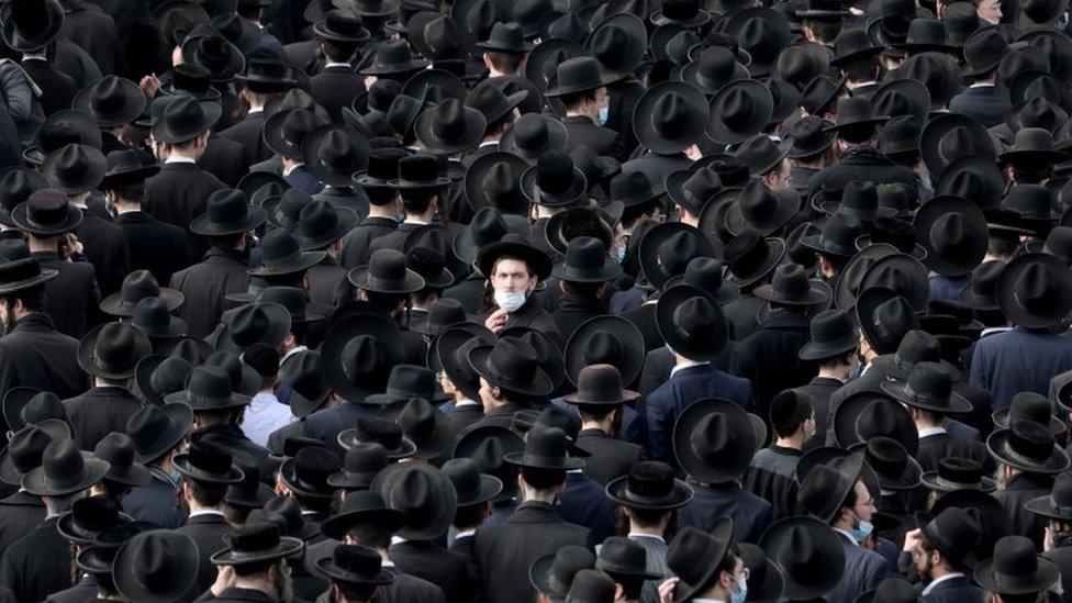 A large crowd of mourners, seen from behind