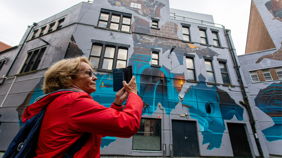 Woman taking picture of the mural