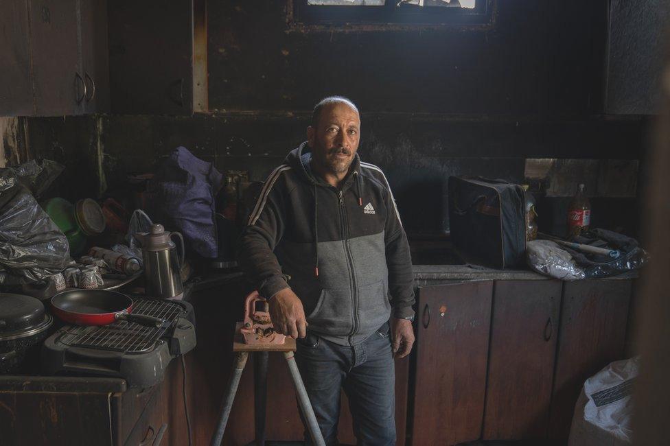 Murad Dawbsheh stands in the ruins of a kitchen in a new home he built for his son.