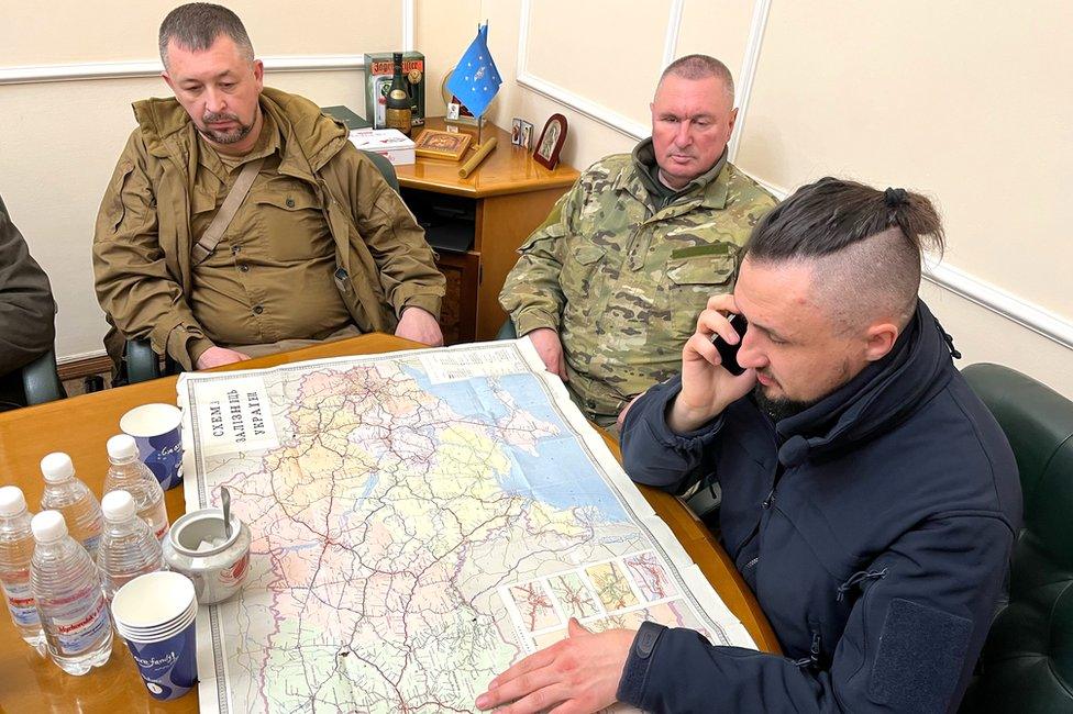 Oleksandr Kamyshin (R) studies a map along with his advisors