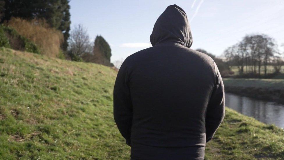 Anonymous shot of "John" walking along a river