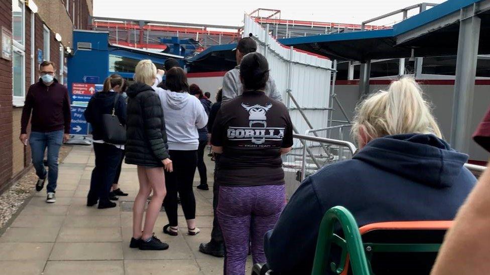 People queuing to get inside a hospital