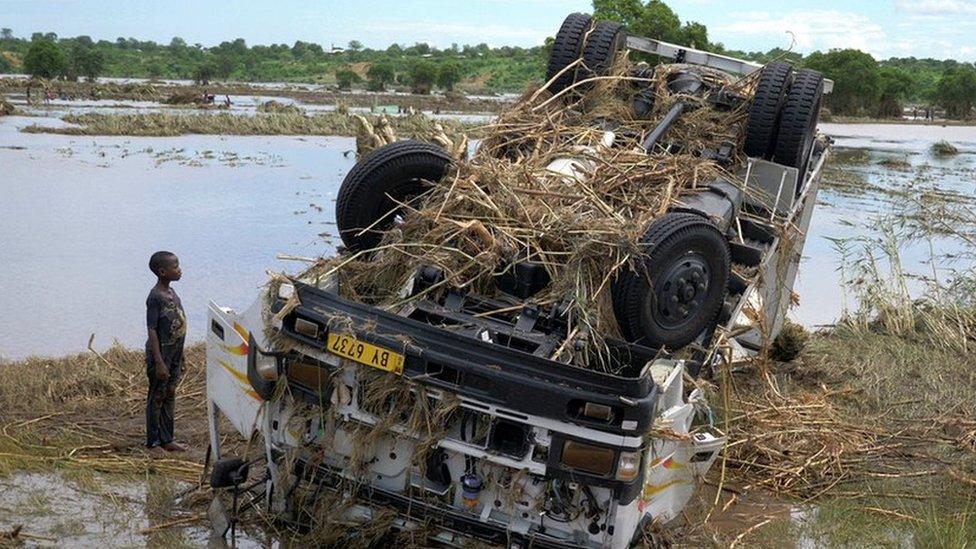 Locals look at a wreck washed away during tropical storm Ana on the flooded Shire river, an outlet of Lake Malawi at Thabwa village