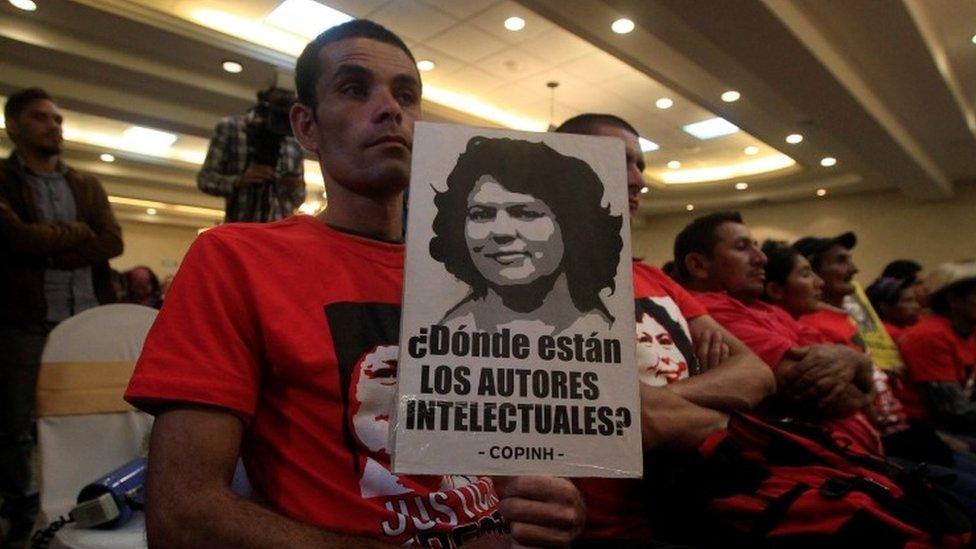 A man hods a poster demaning information about the death of Berta Caseres. 31 Oct 2017