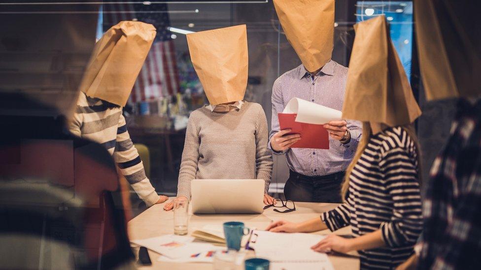 Workers with paper bags over their heads