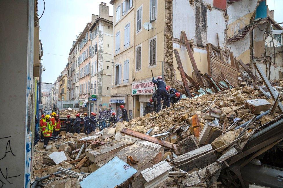 Firemen working and removing rubble at the site where two buildings collapsed, on November 5, 2018 in Marseille