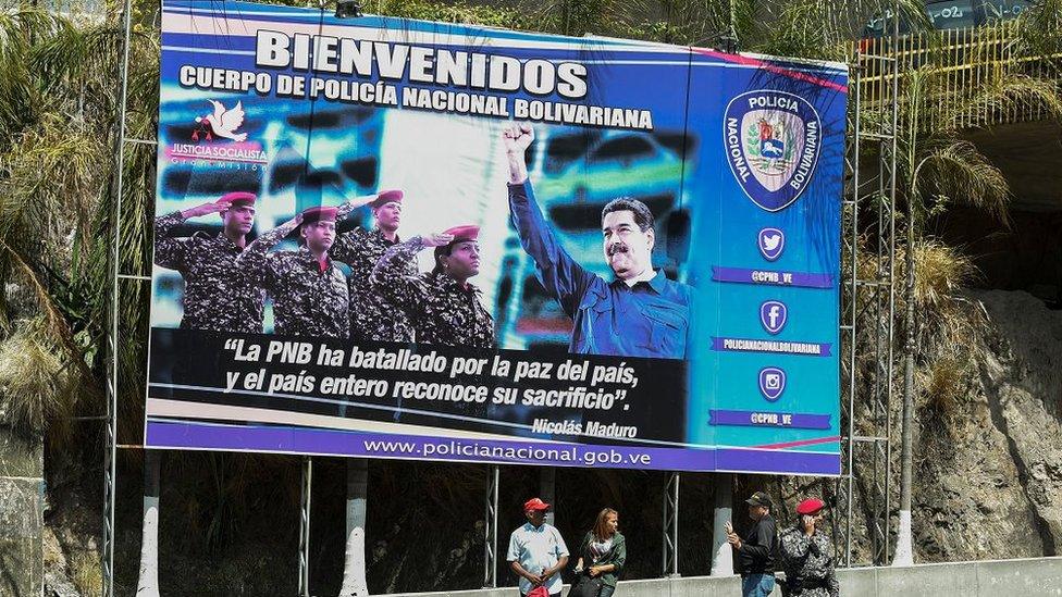 A poster of President Nicolas Maduro and security forces at the entrance of El Helicoide jail in Caracas