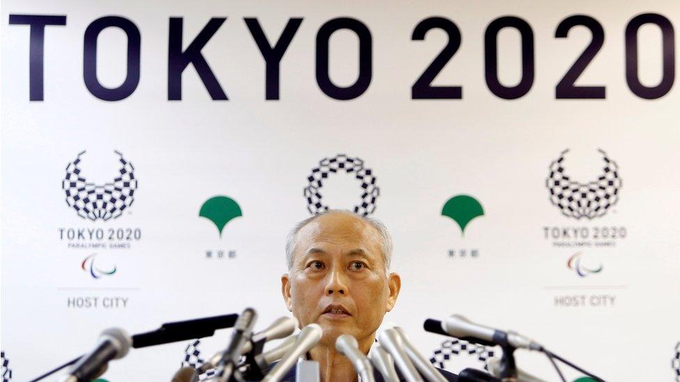 Tokyo governor Yoichi Masuzoe, sat behind a large number of microphones and in front of a wall display reading "Tokyo 2010", at a news conference in Tokyo on 27 May 2016.