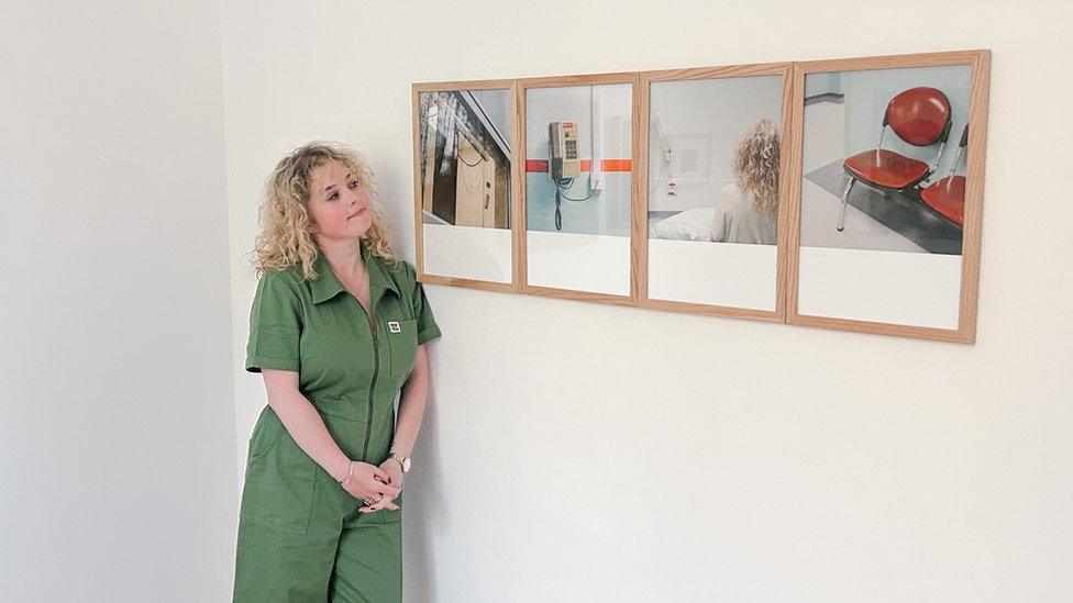 Cíara Hillyer standing beside her final project portfolio titled 'Breathing Space' picturing moments inside a hospital