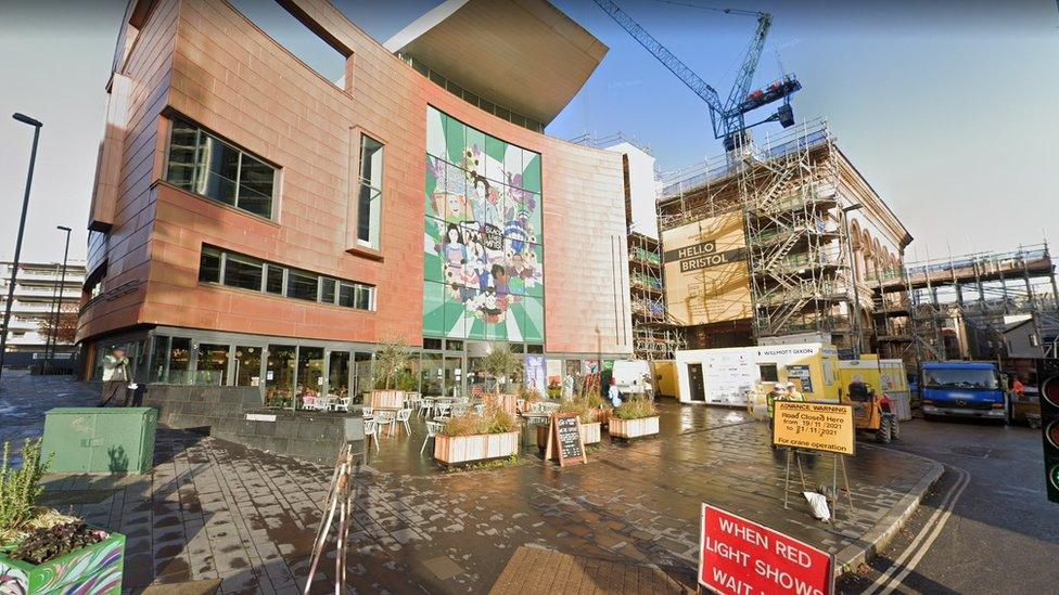 Bristol Beacon as it looked in November 2021 with scaffolding and road signs for temporary traffic lights. You can see a mural on the side of the building