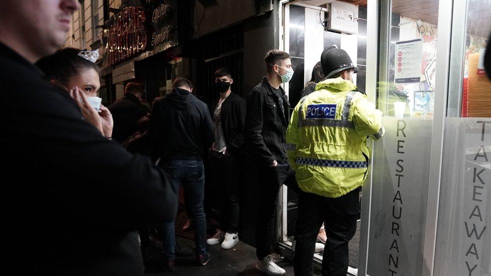 A police officer reminds workers in Newcastle city centre of the 10pm curfew that pubs and restaurants in England are subject to in order to combat the rise in coronavirus cases.