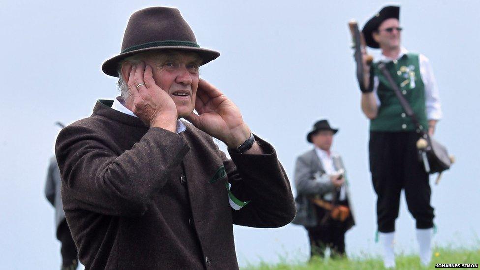 Traditional Bavarian boeller gunner protects his ears during a shoot