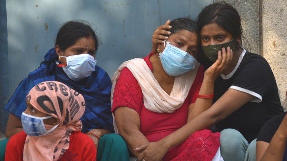 Grieving family members of victims at a cremation ground in Delhi