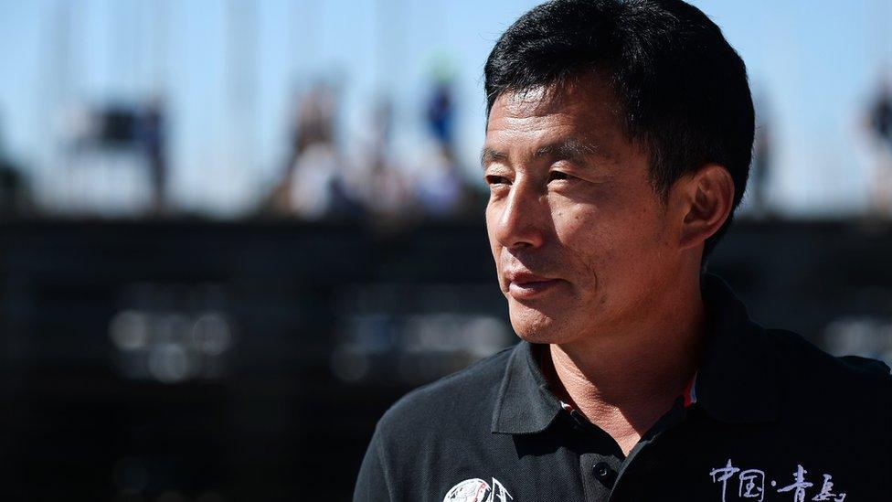 Guo Chuan poses aboard his 'Qingdao China' multihull on August 8, 2015 in La Trinité-sur-Mer, western France.