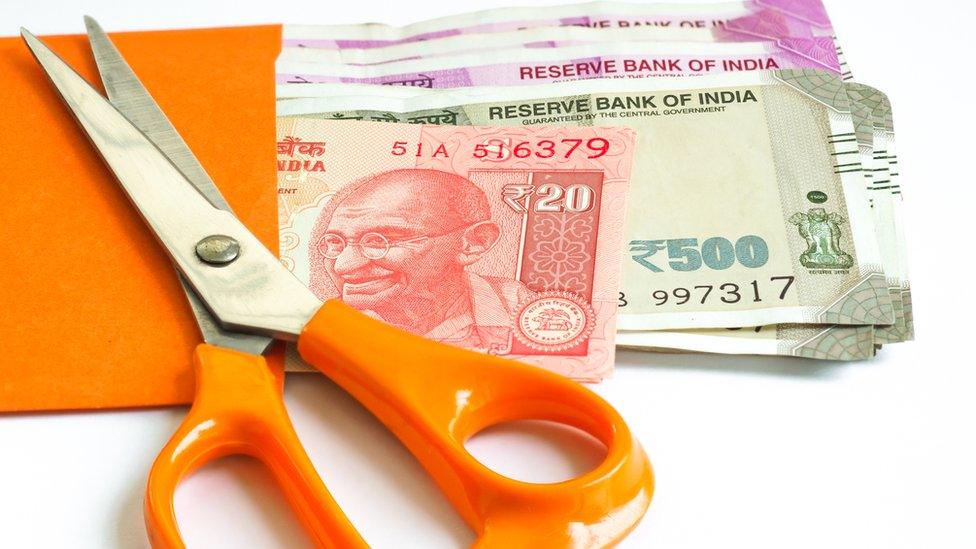 Indian cash in an envelope with scissors