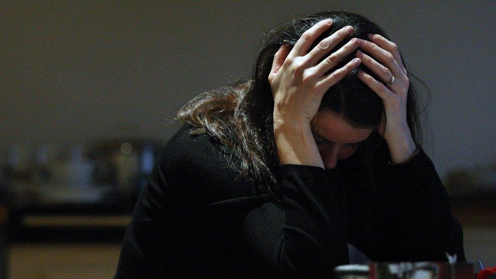 File photo of a woman with her head in her hands