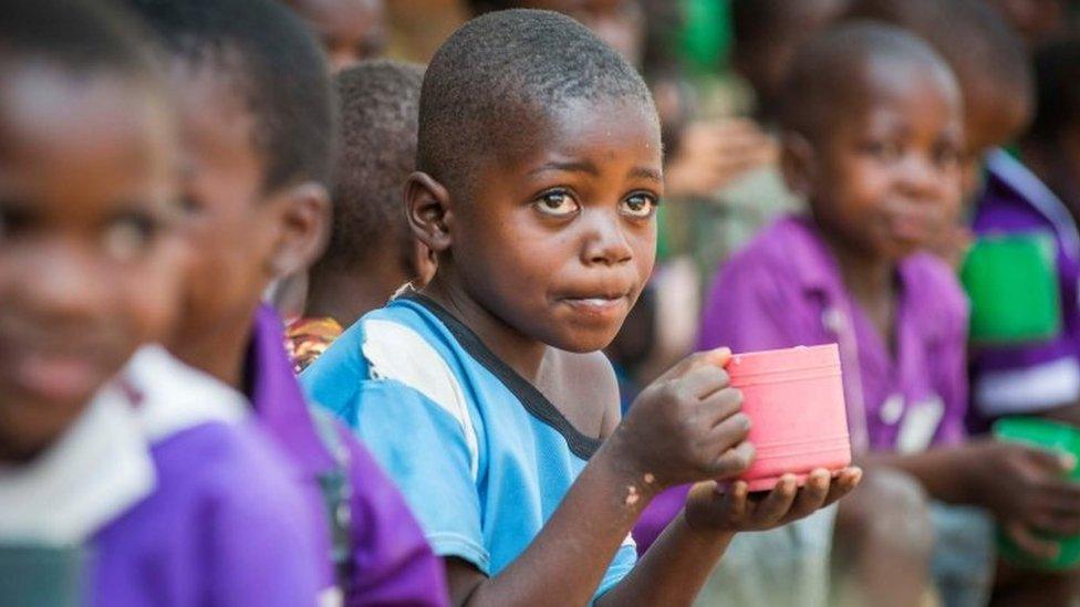 Child in Malawi being helped by Mary's Meals charity with food aid