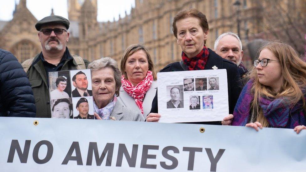 demonstrators holding photos of their loved ones and a banner that says No Amnesty