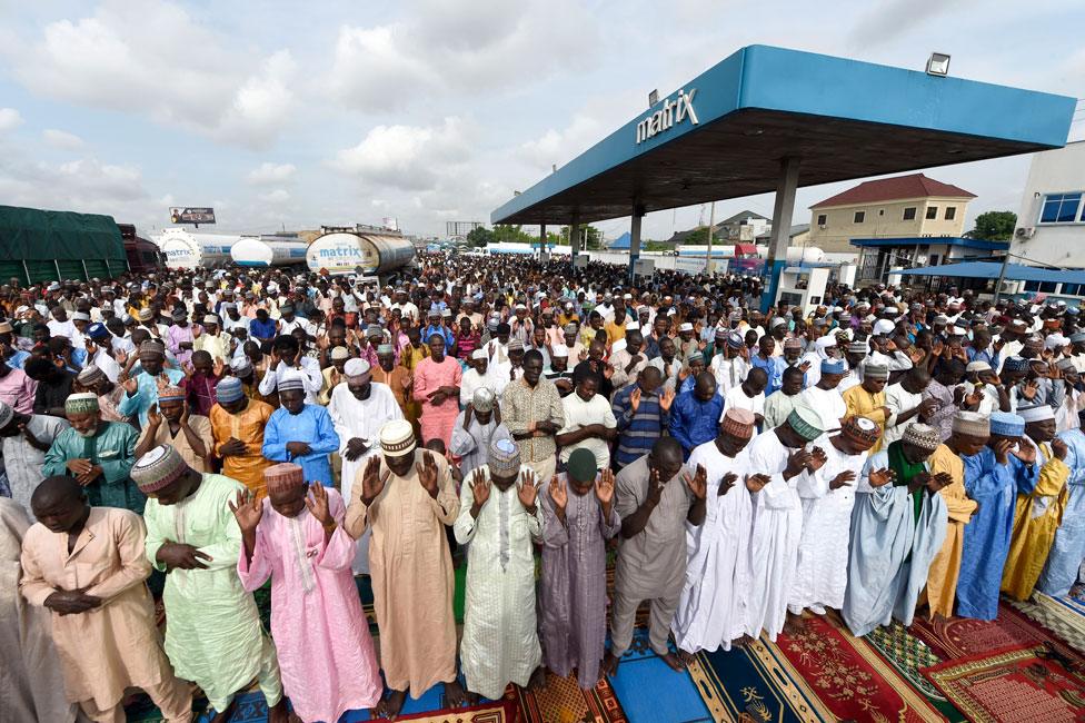 Muslims pray next to a petrol station in Kara Isheri in Ogun State, southwest Nigeria