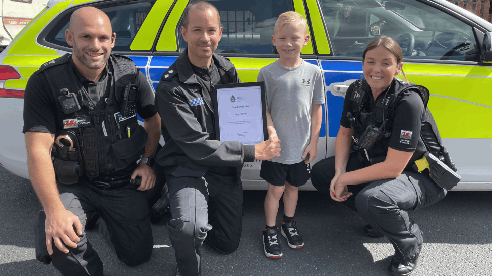 Sunny receives his bravery award from with PC Gary Yarwood, Insp Luke Hughes and PC Emma Horne