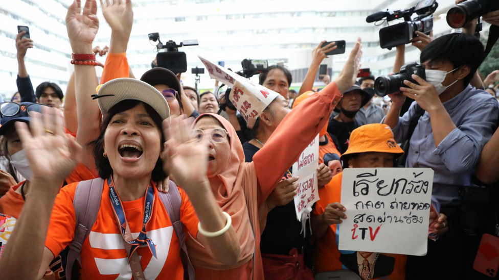 Move Forward supporters wave their hands and cheer outside the court