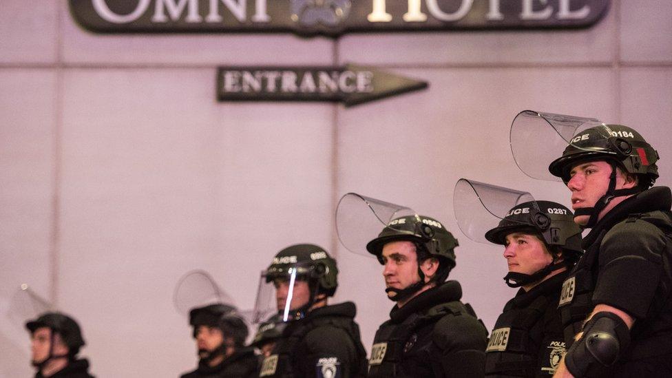 Police officers watch protests near the Omni Hotel 22 September, 2016 in downtown Charlotte, NC