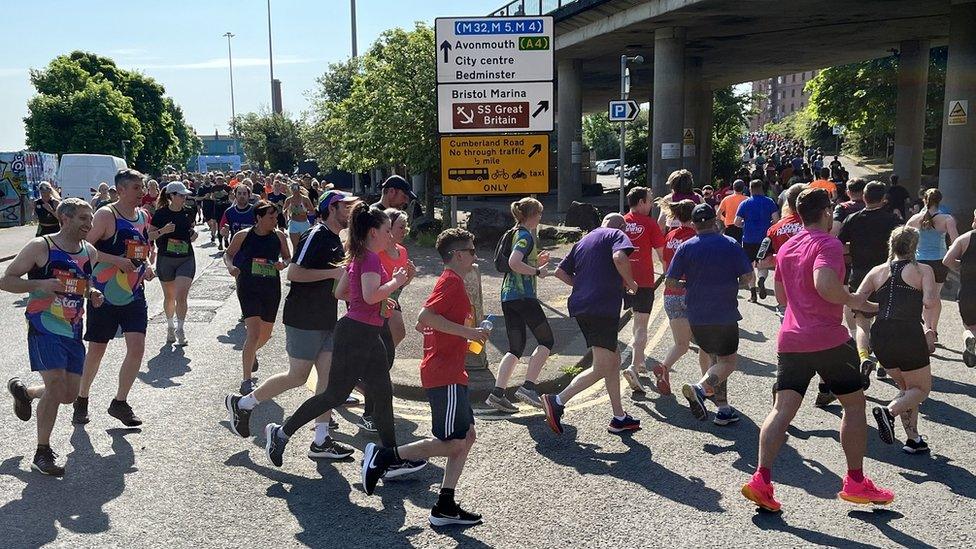 Runners in the Bristol 10k 2024 go around a corner near the Create Centre