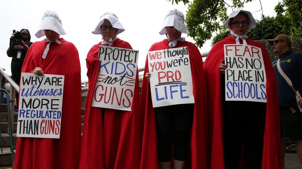 Activists wear red robes and white bonnets based on "The Handmaid's Tale" before the "March for Our Lives"