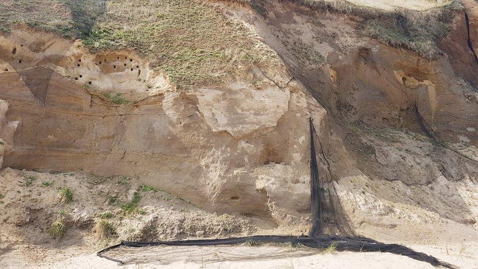 Net hanging from sand cliffs