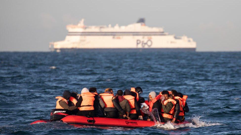 Migrant boat crossing the channel, large ferry behind