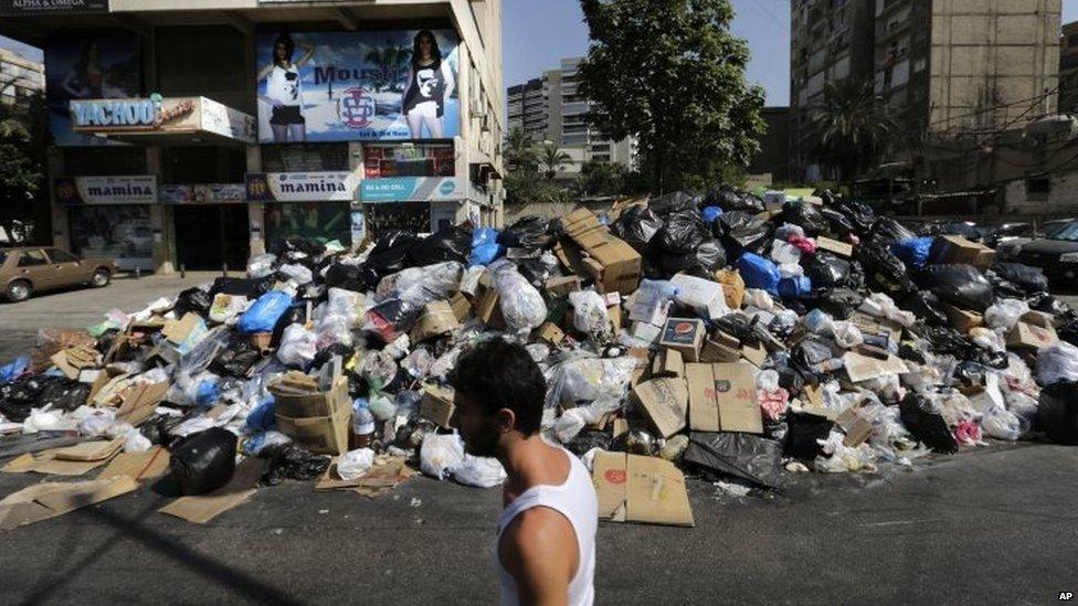 A Lebanese man passes a pile of garbage blocking a street in east Beirut (17 July 2015)