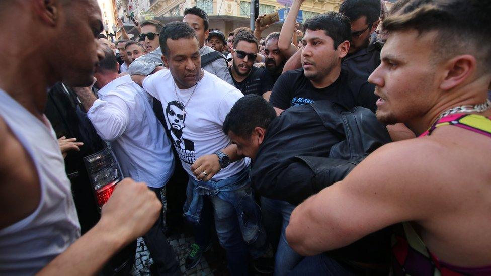 People surround a man suspected of stabbing Brazilian presidential candidate Jair Bolsonaro (not pictured) as he was campaigning in Juiz de Fora, Minas Gerais state, Brazil September 6, 2018