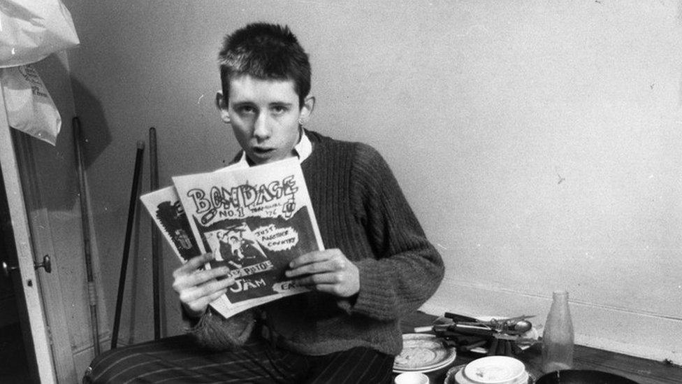 Shane MacGowan holding a copy of the fanzine, Bondage