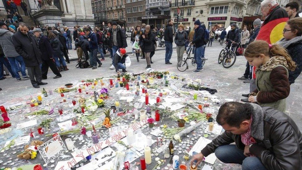 People gather and pay tribute to the many people killed and injured in the terrorist attacks of 22 March, at Place de la Bourse in Brussels