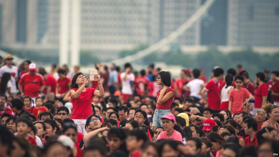 Spectators line the streets for independence day celebrations in Singapore