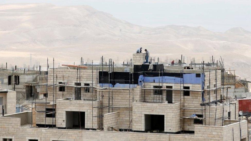 Workers on a construction site in the West Bank settlement of Maale Adumim